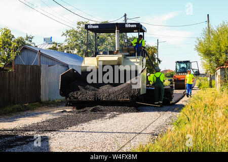 Targoviste, Roumanie - 2019. Fermer la vue sur les travailleurs et le bitumage des machines. Construction de nouvelle route avec l'appui de l'Union européenne struc Banque D'Images