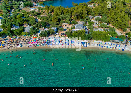 Vue aérienne de l'Aliki Beach avec parasols colorés, à l'île de Thassos, Grèce. Piscine personnes en mer Banque D'Images