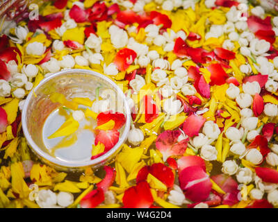 Avec de l'eau dans l'eau de parfum thaï balancier avec des fleurs colorées et des pétales garland pour Songkran festival, Thaïlande, Bol à fleurs, comme le jasmin, le ro Banque D'Images