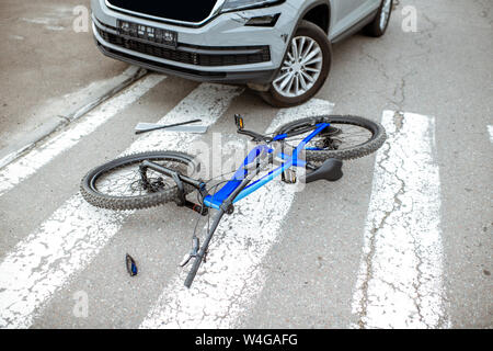 Lieux d'un accident de la route avec voiture et location brisé gisant sur le passage pour piétons Banque D'Images