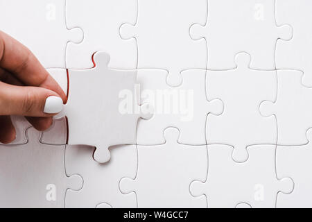 Top View of woman holding white jigsaw près de connecté des pièces de puzzle Banque D'Images