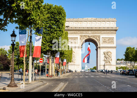 Pour Bastille Day un grand drapeau français vole sous l'Arc de Triomphe à Paris, France, et de l'avenue des Champs-Elysées est paré de drapeaux français. Banque D'Images