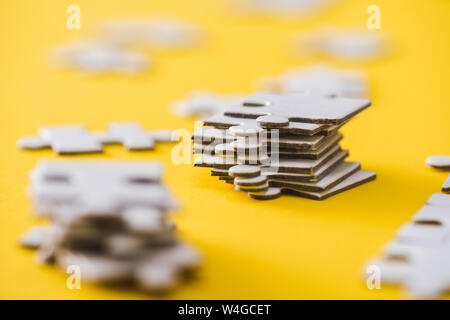 Focus sélectif des pièces de puzzle blanc sur jaune Banque D'Images