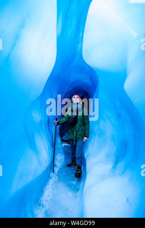Femme debout dans une grotte de glace, Fox Glacier, île du Sud, Nouvelle-Zélande