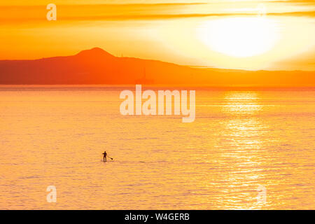 L'homme sur le stand up paddle board au coucher du soleil, North Berwick, East Lothian, Scotland Banque D'Images