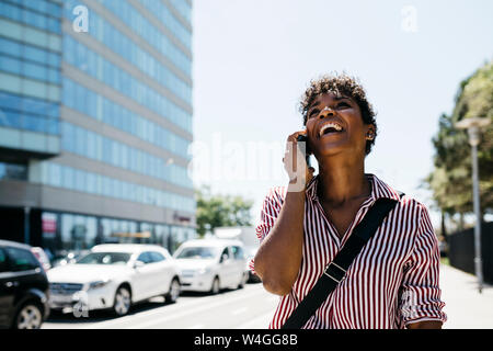 Femme parlant au téléphone tout en marchant dans la ville Banque D'Images