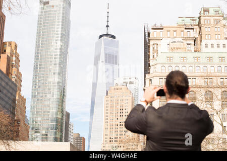 Vue arrière de l'homme à prendre des photos avec le smartphone, New York City, USA Banque D'Images