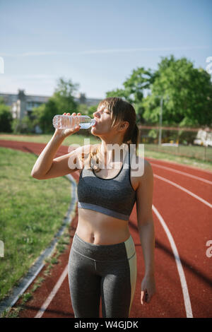 L'eau potable de la sportive sur racetrack Banque D'Images