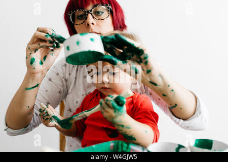 Mère et fille faisant l'artisanat à la maison la peinture des bobines de carton Banque D'Images