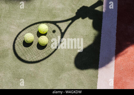 Ombre d'un joueur de tennis avec balles et racket sur cour Banque D'Images