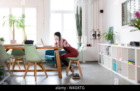 Woman at table in modern office Banque D'Images