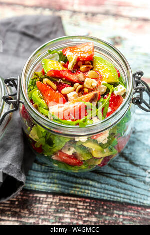 Salade d'avocat aux fraises, la roquette et les pignons de pin dans le jar Banque D'Images