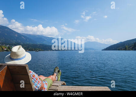 L'homme se reposant à Lakeshore, Seeboden, Lac de Millstatt, Carinthie, Autriche Banque D'Images