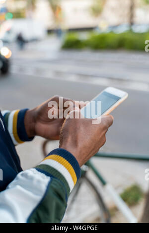 Close-up of man using cell phone in the city Banque D'Images