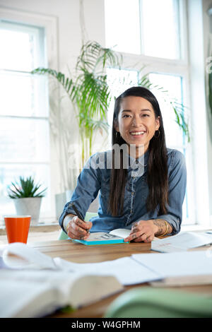 Portrait of happy woman working at table in office