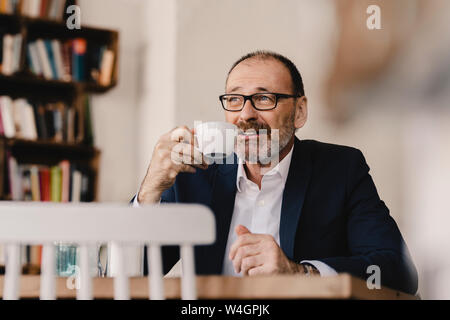 Homme d'âge mûr ayant un café dans un café Banque D'Images