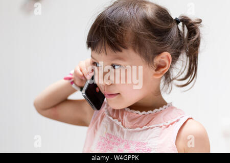 Portrait of smiling little girl on the phone Banque D'Images