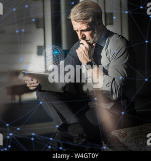 Mature businessman using tablet entouré de monde virtuel et de lignes Banque D'Images