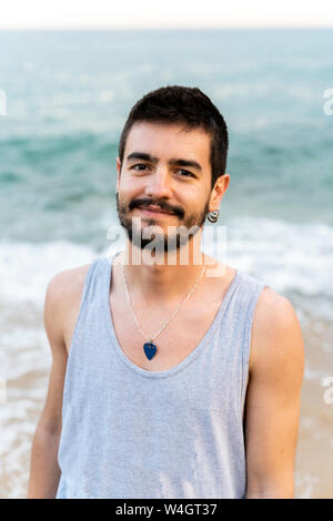 Portrait of smiling young man sur la plage Banque D'Images