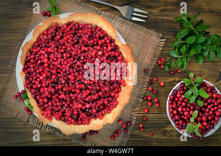 Airelle rouge appétissant gâteau et les baies fraîches airelle rouge sur fond de bois, vue du dessus Banque D'Images