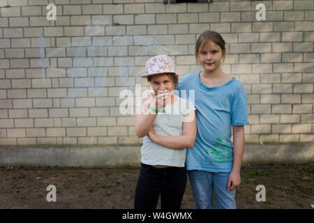 Portrait de deux jeunes filles debout devant un mur de briques Banque D'Images