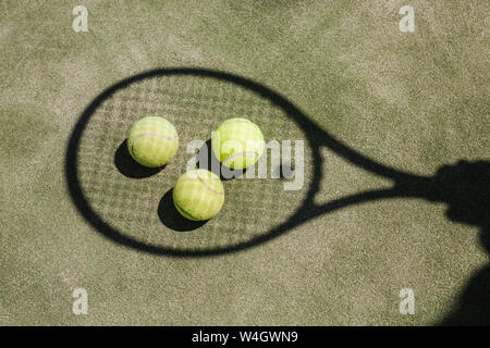 Ombre d'un joueur de tennis avec balles et racket sur cour Banque D'Images