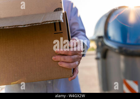 Man carrying cardboard box en carton de recyclage Banque D'Images