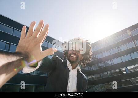 Happy businessman giving high-cinq à l'extérieur du bureau Banque D'Images