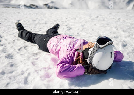 Femme en faisant une pause après le ski allongé sur le sol enneigé en Sierra Nevada, Andalousie, Espagne Banque D'Images