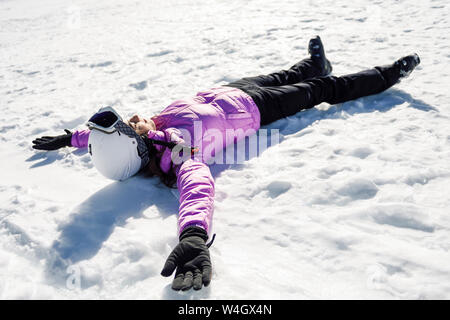 Femme en faisant une pause après le ski allongé sur le sol enneigé en Sierra Nevada, Andalousie, Espagne Banque D'Images