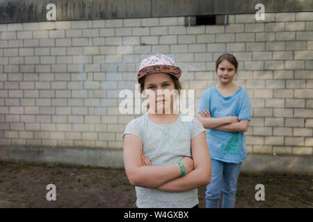 Portrait de deux jeunes filles debout devant un mur de briques Banque D'Images