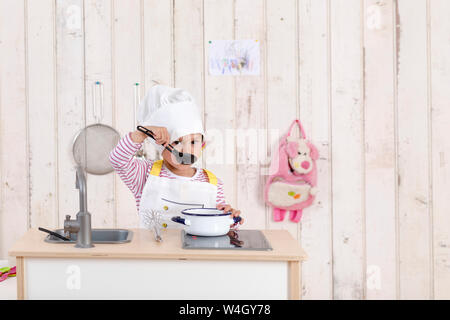 Portrait of little girl Playing with toy cuisine Banque D'Images