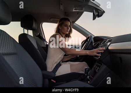 Le choix d'un pilote femme blonde canal radio dans sa voiture Banque D'Images