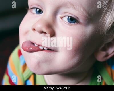 Portrait de petit garçon sticking out tongue Banque D'Images