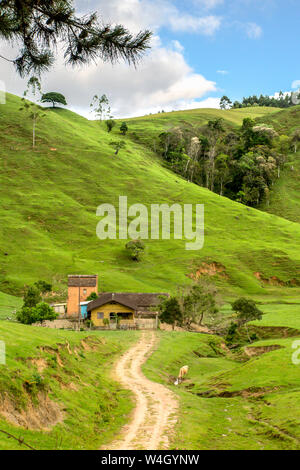 Maison de ferme avec chemin de terre et à l'arrière des pâturages hill, ciel bleu avec des nuages, Presidente Nereu, Santa Catarina