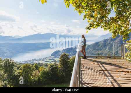 Femme debout sur le point d'observation au-dessus du lac de Millstatt, Carinthie, Autriche Banque D'Images