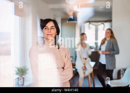 Filles visiter leur mère, qui est à la recherche par la fenêtre Banque D'Images