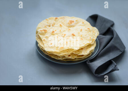 Pile de pita, pain arabe, du pain plat sur fond de bois gris. Soft focus. Les aliments traditionnels arabes Banque D'Images