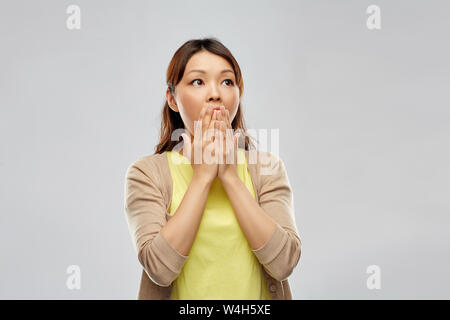 Femme asiatique peur sur fond gris Banque D'Images