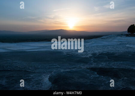 Turquie : coucher de soleil sur la terrasses en travertin à Pamukkale (château de coton), site naturel de roches sédimentaires déposées par l'eau des sources chaudes, Banque D'Images