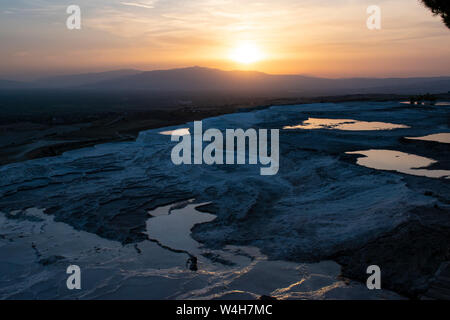 Turquie : coucher de soleil sur la terrasses en travertin à Pamukkale (château de coton), site naturel de roches sédimentaires déposées par l'eau des sources chaudes, Banque D'Images