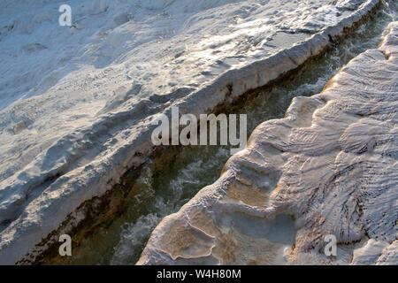 Turquie : l'eau vive à partir de hot springs, sur la terrasses en travertin à Pamukkale (château de coton), un site naturel de roches sédimentaires déposées par l'eau Banque D'Images