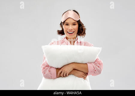 Femme avec coussin dans pajama et des yeux masque de sommeil Banque D'Images