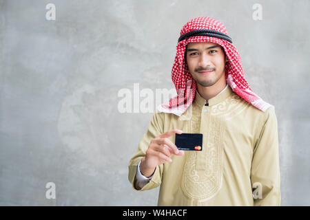 Bel homme arabe moderne montrant une carte de crédit Banque D'Images