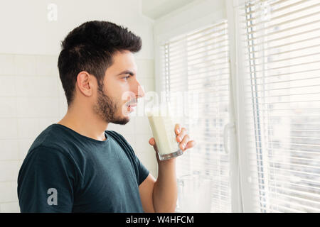 Un jeune homme s'est préparé pour le petit déjeuner un smoothie de légumes Lait et fruits frais. Il mène une vie saine. Banque D'Images