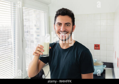 Un jeune homme s'est préparé pour le petit déjeuner un smoothie de légumes Lait et fruits frais. Il mène une vie saine. Banque D'Images