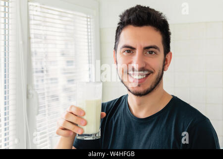 Un jeune homme s'est préparé pour le petit déjeuner un smoothie de légumes Lait et fruits frais. Il mène une vie saine. Banque D'Images