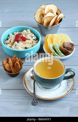 Petit-déjeuner : avoine avec morceaux de fruits confits et de fraises, des morceaux de confit d'ananas, de kiwi et de mangue, figues séchées, chips de pomme et de poire en petits Banque D'Images