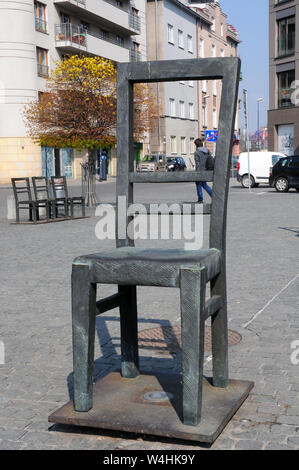 Grand président, et trois petites chaises, (représentant des enfants) dans le monument de la Place des Héros du ghetto, Cracovie, la Petite Pologne. Banque D'Images