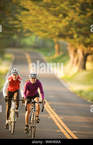 Vélo femme avec un homme plus âgé sur une route de campagne Banque D'Images